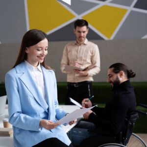Team discussion addressing psychosocial hazards in an inclusive workspace, with diverse team members including a wheelchair user